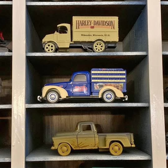 Diecast vehicle set with three trucks and cars, including Harley-Davidson box