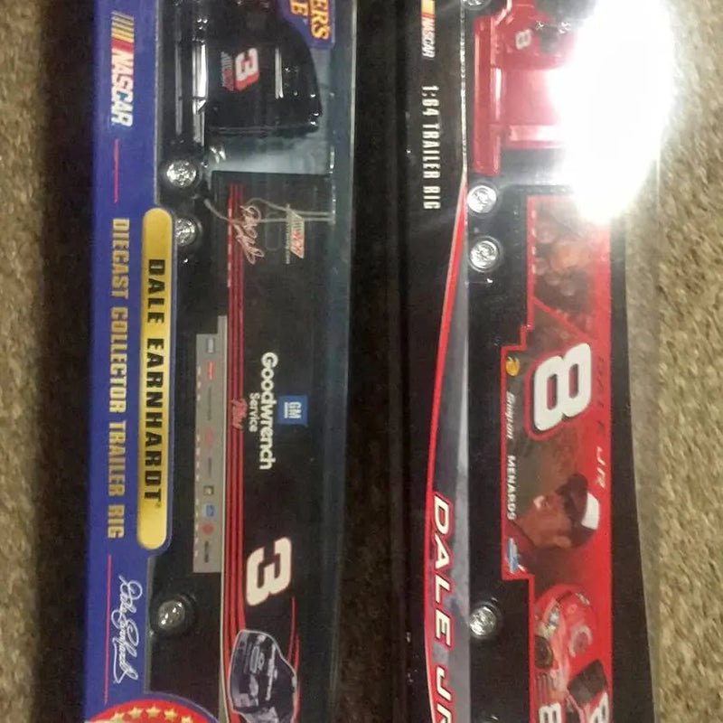 Diecast trailer rig toy in retail packaging, black truck and red truck