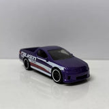 Purple diecast UTE model car with white and red racing stripes, black wheels
