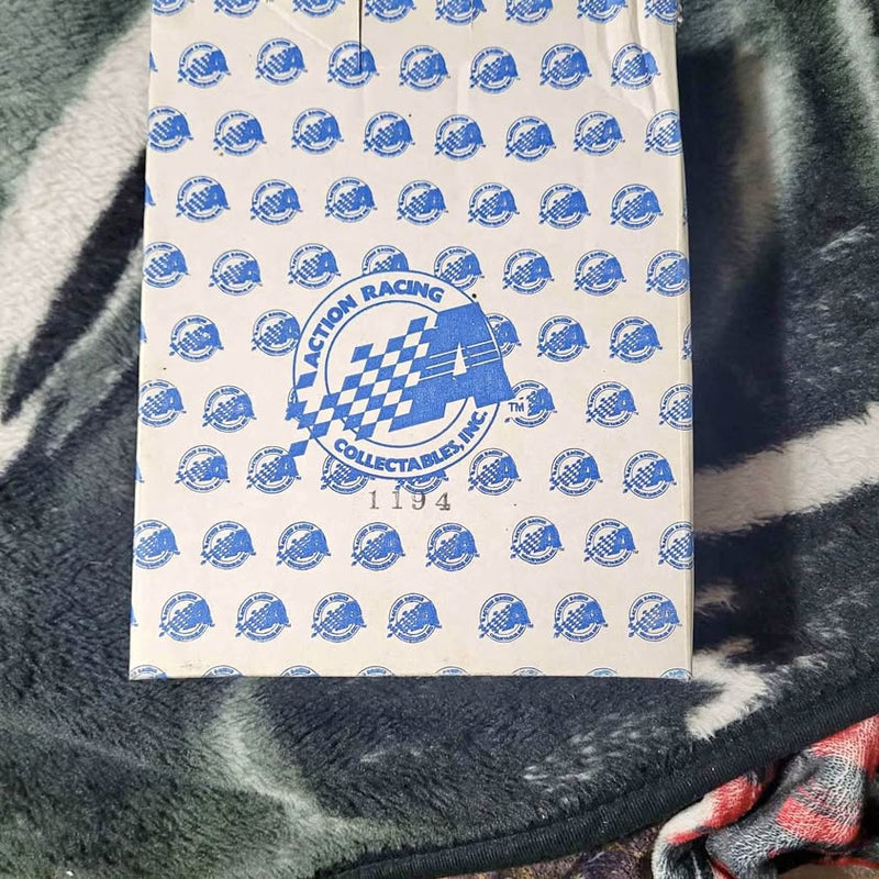 White racing graphic shirt with blue checkered logo and patterned emblems