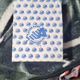 White racing graphic shirt with blue checkered logo and patterned emblems