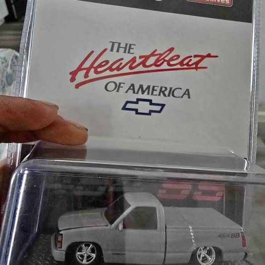 Diecast pickup truck model in a clear display window, light gray cab and bed