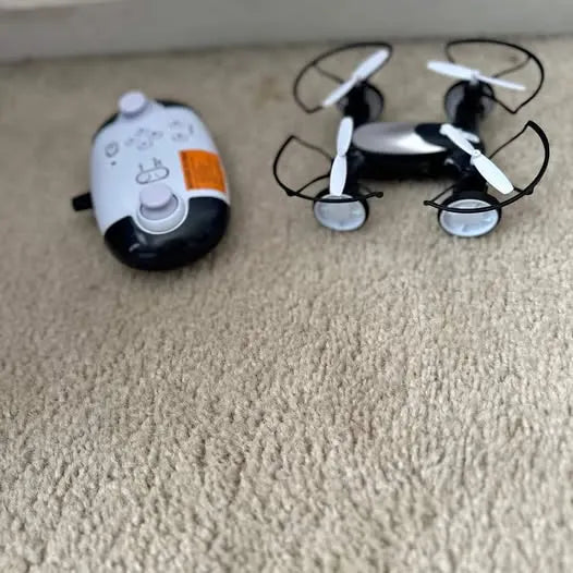 Toy quadcopter drone with controller, white and orange