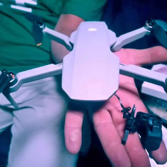 DJI Mini 2 SE drone with white body and fold-out propellers held in hand