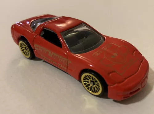 Red diecast Corvette toy car with gold rims, black window accents