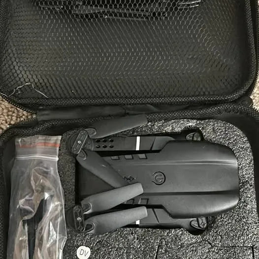 Foldable grey drone with propellers and arms in carry case, front view