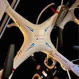 White quadcopter drone body with SYMAX markings and four propeller arms