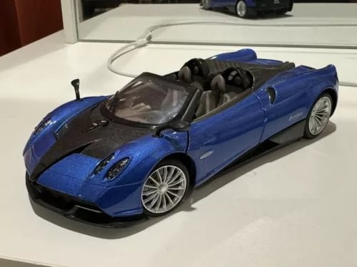 Blue roadster diecast model car with open cockpit, black hood accents, silver detailed wheels