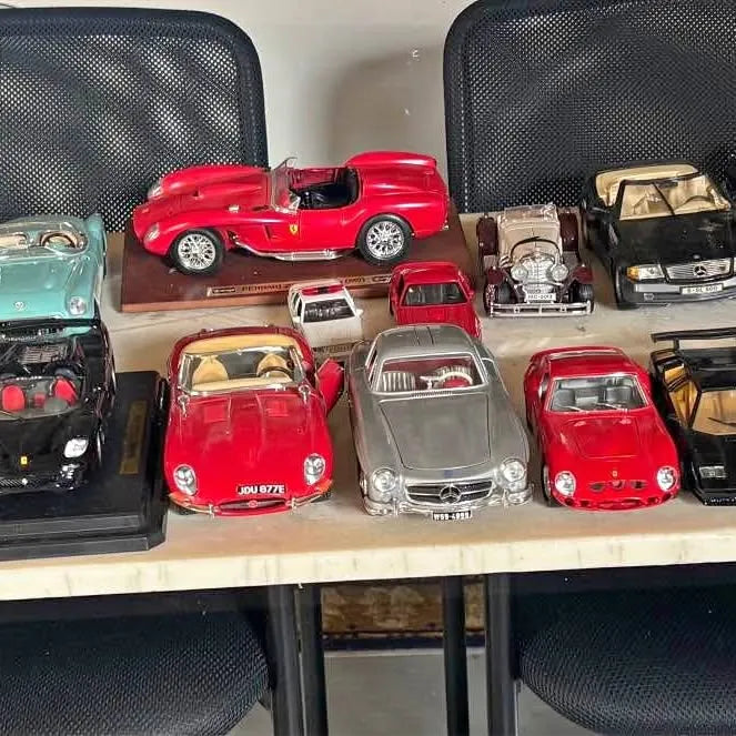 Die-cast model car assortment, red and black vehicles on a display shelf.