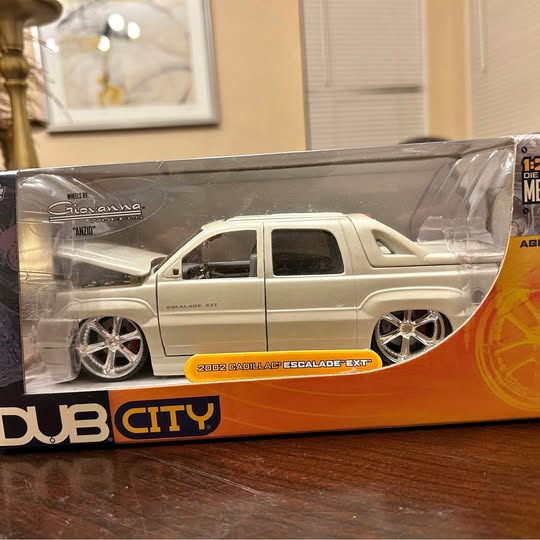 Silver diecast SUV toy car model in clear display box