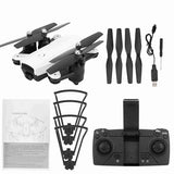 White folding RC drone with controller, spare propellers, USB cable and manuals.