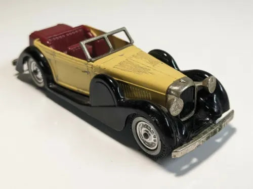 Yellow and black diecast convertible car with maroon interior, open top.