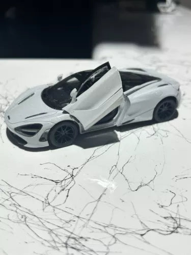 White 1:36 diecast sports car toy with raised door, detailed wheels and front lights