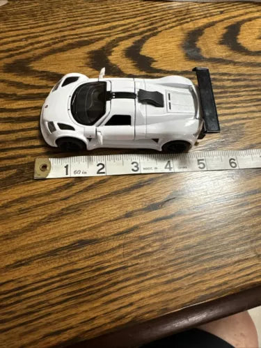White 1/36 scale diecast pull-back sports car with black trim, top view.