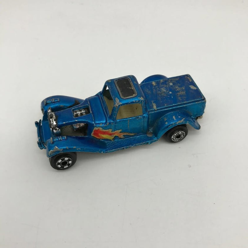Blue diecast pickup truck toy with flame graphic, vintage design, side view