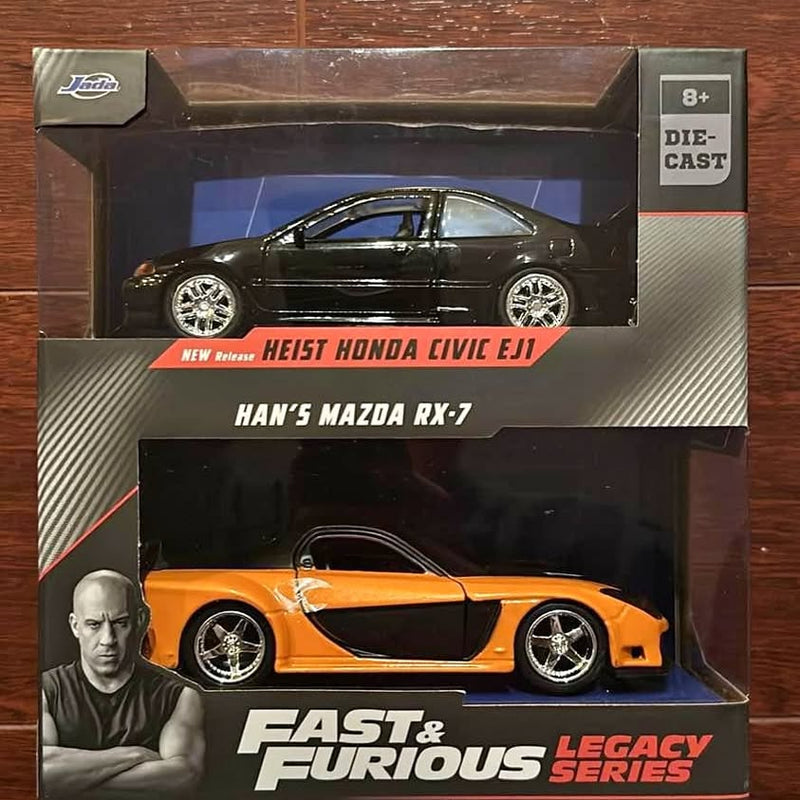 Orange die-cast sports car model with black hood and silver wheels in retail box
