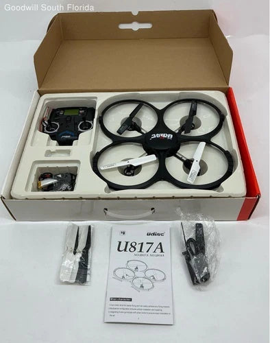 Black quadcopter drone with four propellers and remote control in open box