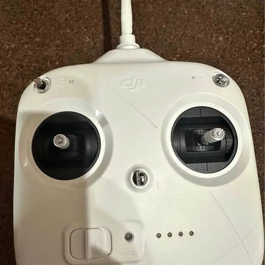 White DJI drone remote controller with two front dials and antenna base.