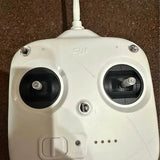 White DJI drone remote controller with two front dials and antenna base.