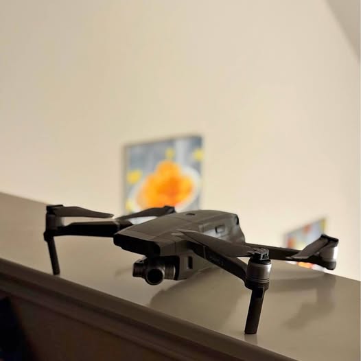 Foldable quadcopter drone with front camera gimbal in dark gray.