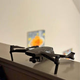 Foldable quadcopter drone with front camera gimbal in dark gray.