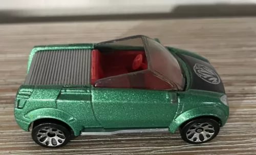 Green die-cast model car with red interior, side view