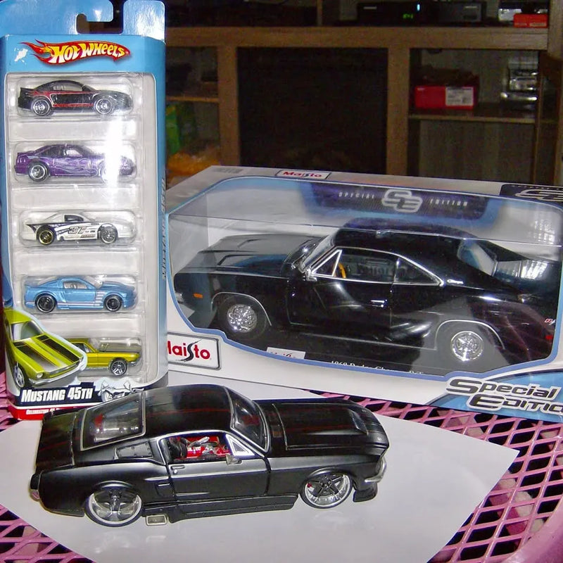 Black diecast muscle car model in display box with clear window