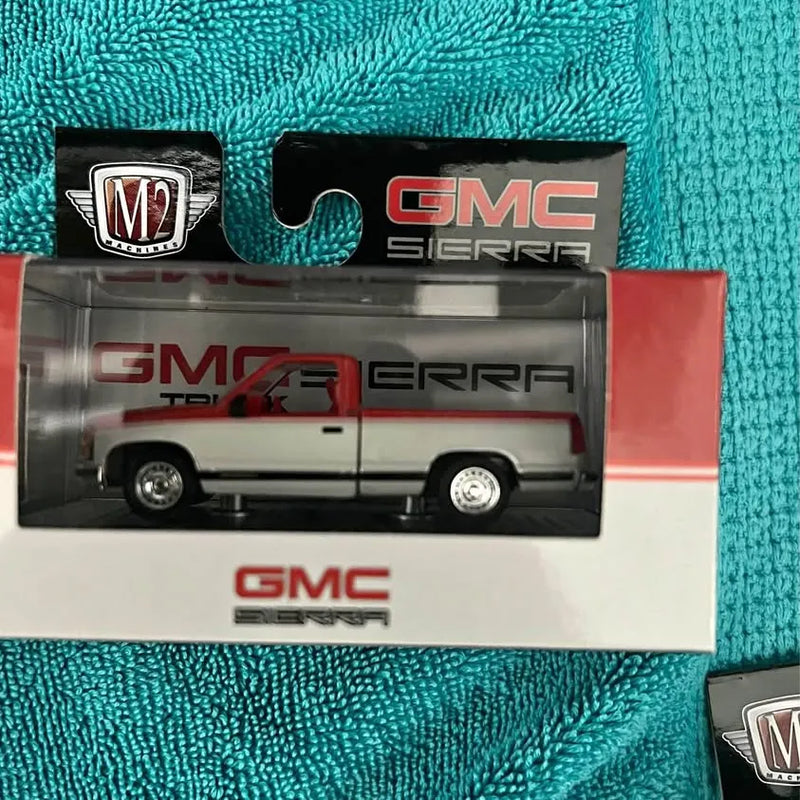 Boxed GMC Sierra diecast truck model with M2 logo and clear window packaging