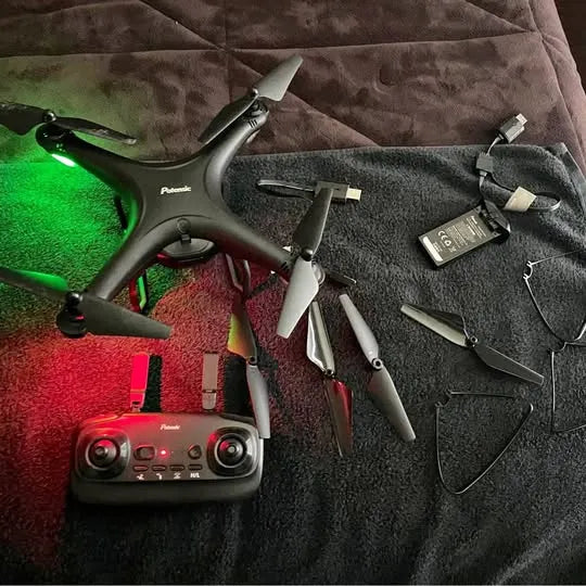 Drone with camera and remote controller, propellers, battery, and charging cable