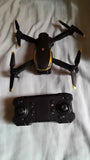 Black quadcopter drone with four propellers and a black remote controller
