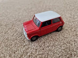 Red diecast Mini Cooper model car with white roof and open windows