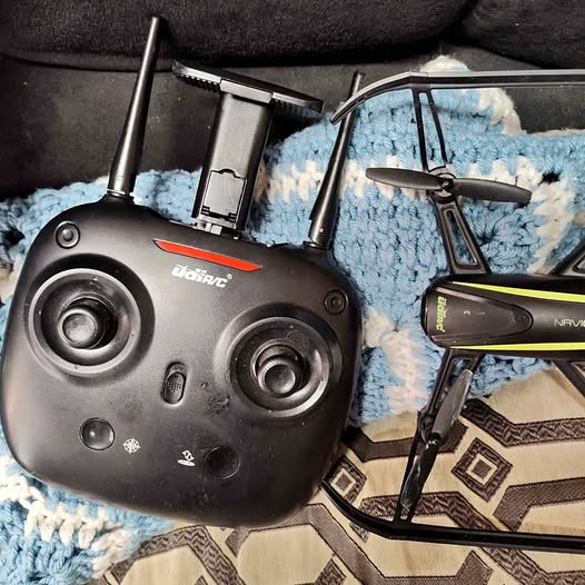 Black RC drone controller with dual joysticks and phone holder