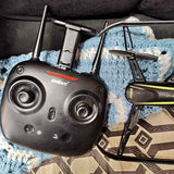Black RC drone controller with dual joysticks and phone holder