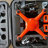 Orange quadcopter drone in open hard case with controller and batteries