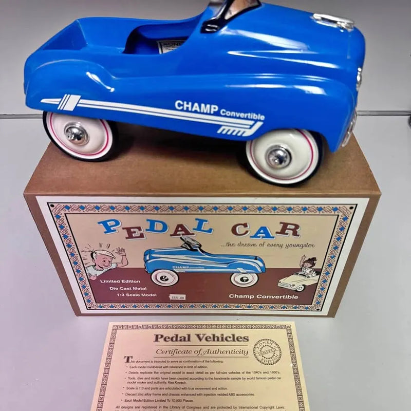 Blue diecast pedal car with Pedal Vehicles authenticity certificate and box