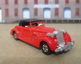 Red vintage diecast coupe roadster model with black roof and chrome details