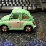 Pastel green Volkswagen Beetle diecast pullback toy car, side view with open windows
