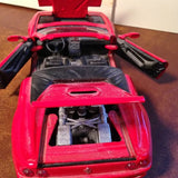 Red 1/24 diecast car model with hood open, showing engine details