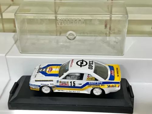 White and blue race car diecast model with number 15 on black display base