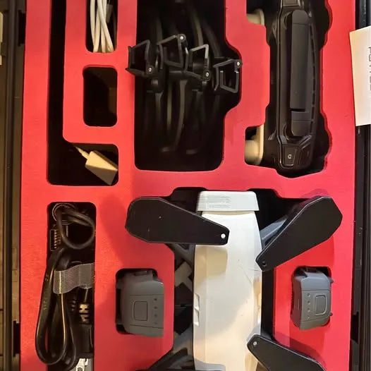 DJI Spark drone kit with remote controller, battery, and charging cables in foam insert