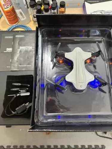 White quadcopter drone with blue LED lights in clear retail box