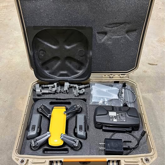 DJI Spark drone case with yellow drone body, remote, battery, and accessories