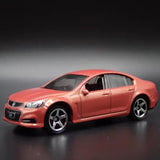 Red 4-door sedan diecast model car, front three-quarter view, silver wheels