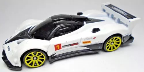 White diecast race car with black cockpit, yellow rims, and red number 1 on door