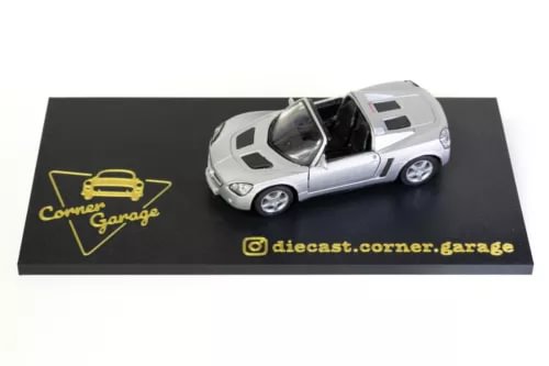Silver 1:34 die-cast model car with windowed box insert, front three-quarter view