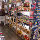 Diecast construction vehicle models on wooden display rack, assorted trucks and equipment