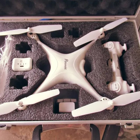 White quadcopter drone with four propellers in open carrying case