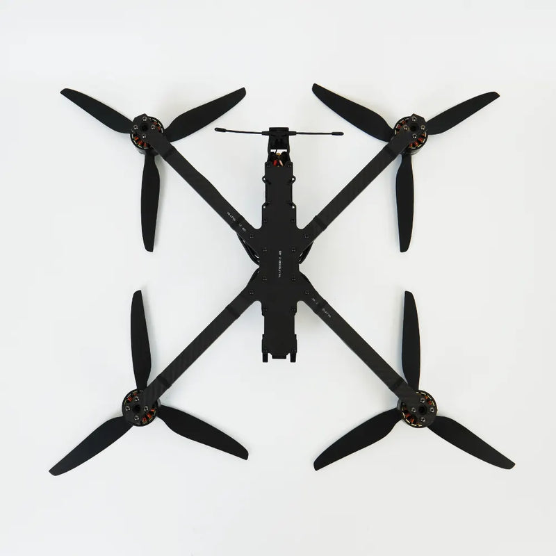 Black quadcopter racing drone with four propellers and central camera module
