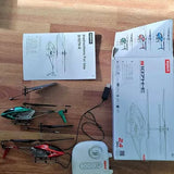 SYMA quadcopter drone set with remote control and instruction manuals on table
