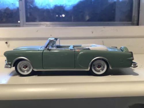 Dark green diecast convertible car, side view, open-top